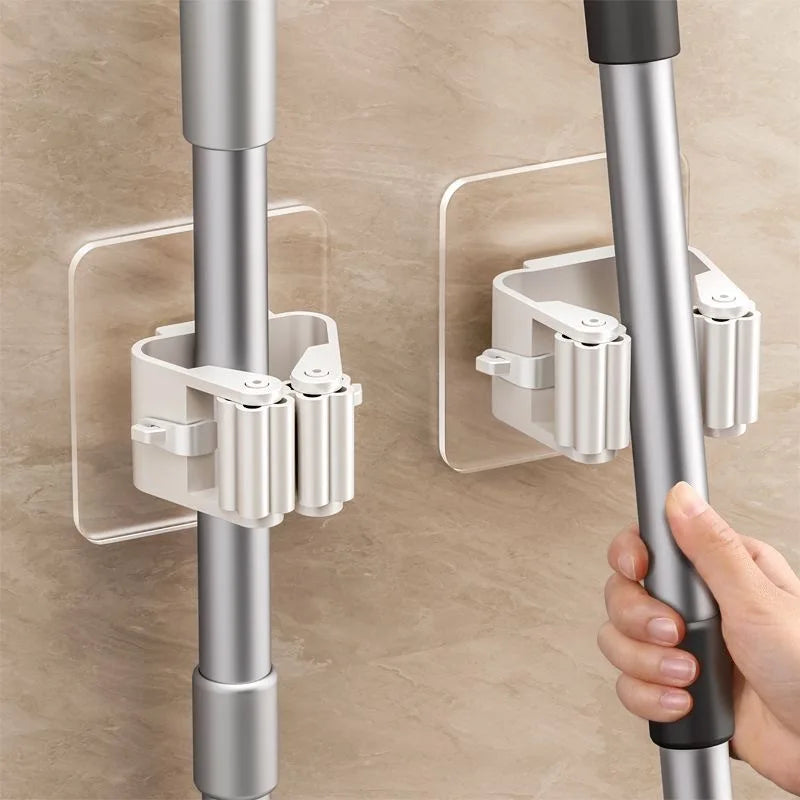 Adhesive mop and broom holder for smooth wall surfaces