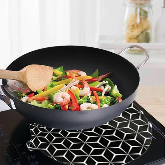 Cooktop protector mat positioned beneath cookware